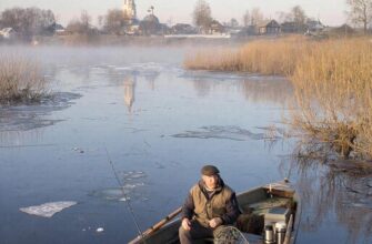 Весенняя рыбалка на Волге на рассвете: лодка в тумане у затопленных ив.